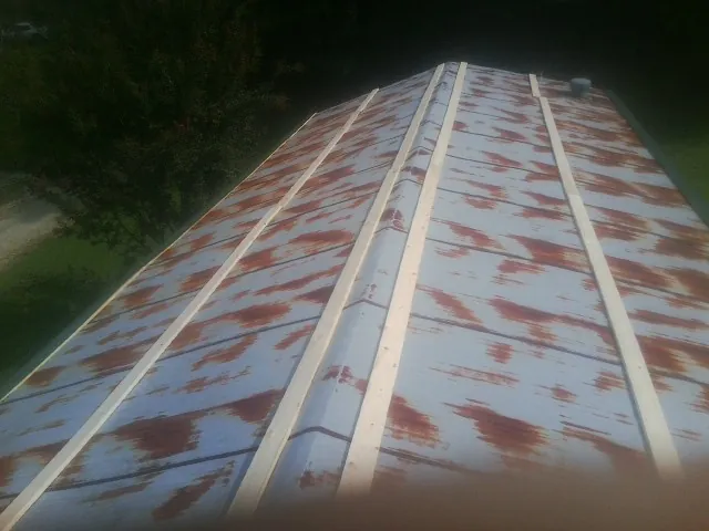 Rusted metal roof panels with new wood purlins before replacement — Storm Damage Roof Repair in Pleasant Grove by Roofing Brothers