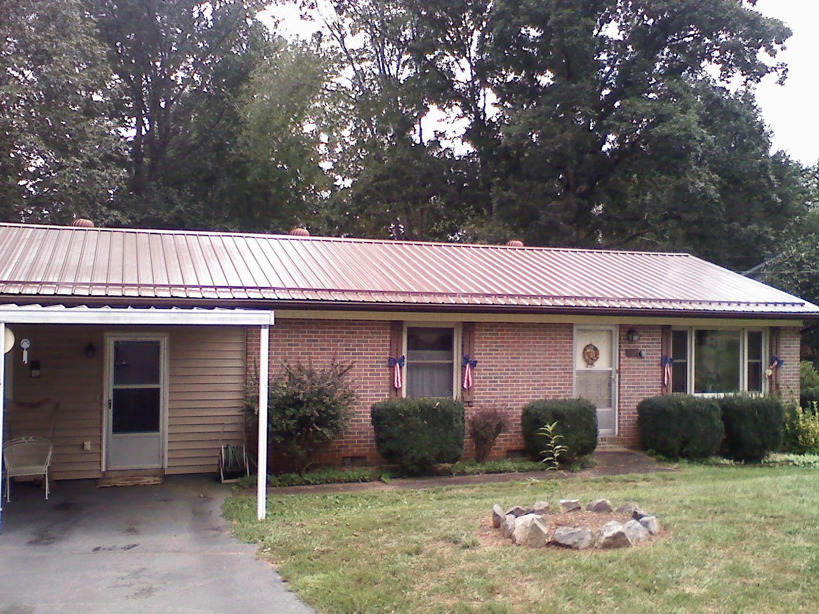 Bronze metal roof and carport on a brick ranch home — Roof Repair work by our crew in Pleasant Grove