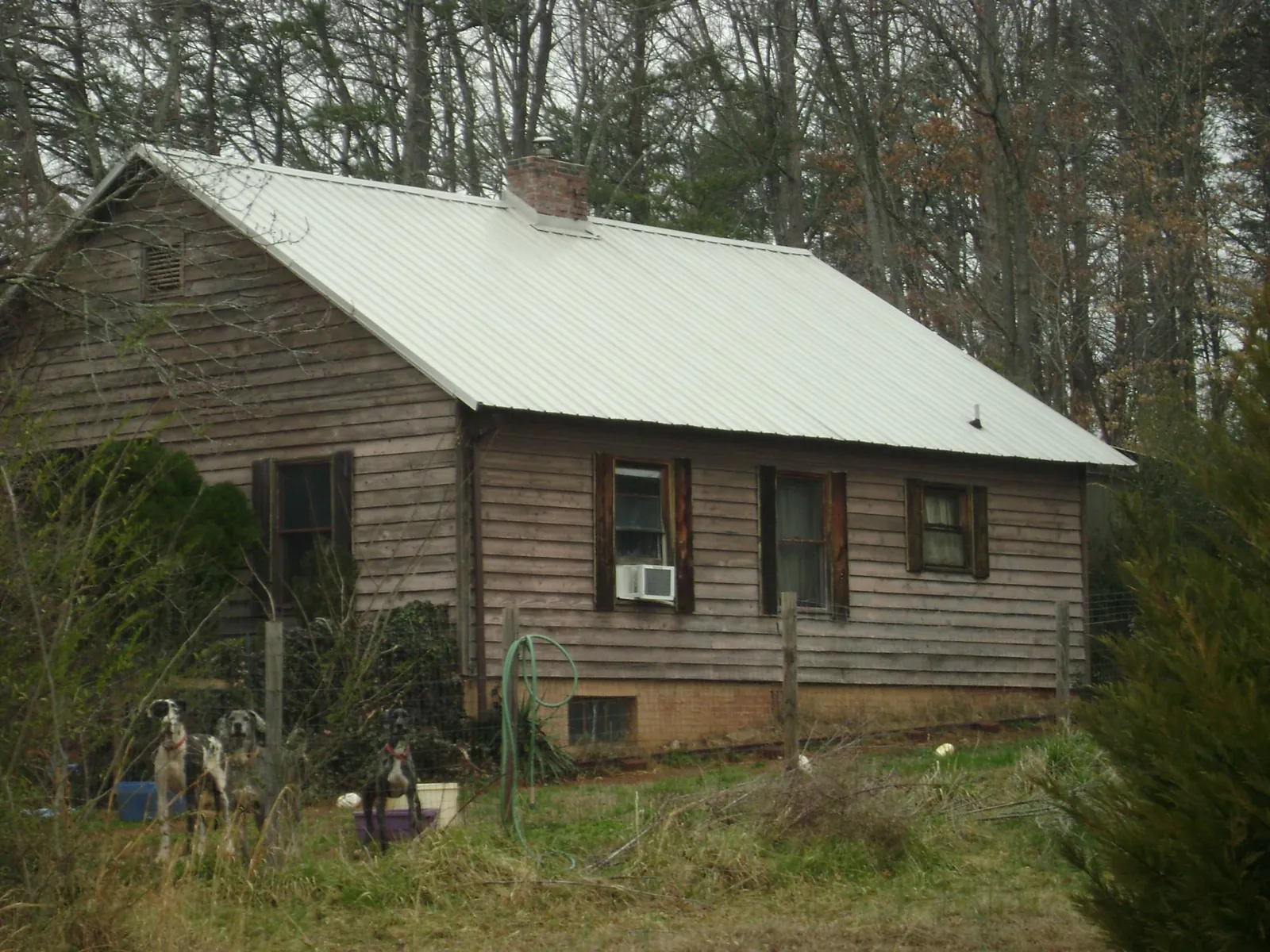 White metal roof on an old wood sided farmhouse, from a Metal Roof Installation job in Pleasant Grove